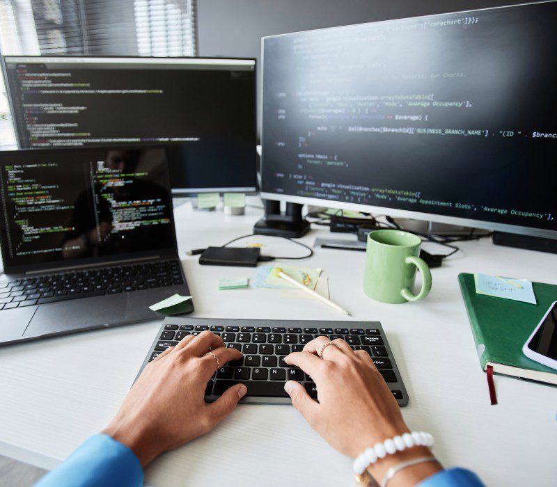 Close up of a young man writing on a computer